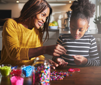 Smiling parent helping child with craft project