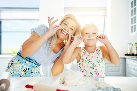 Playful Mum and daughter with pastry mustaches
