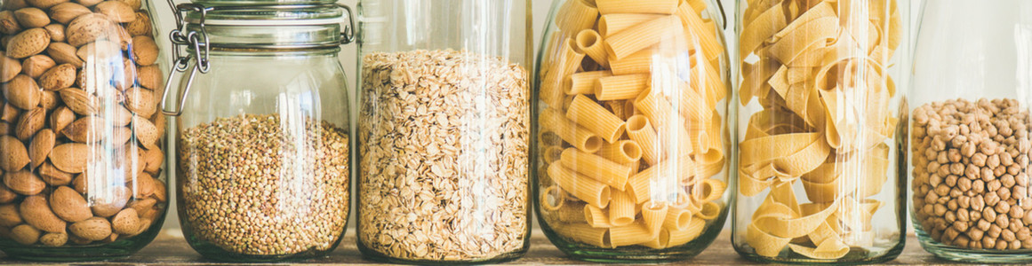 Uncooked cereals  grains  beans and pasta on table  wide composition