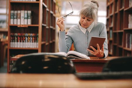 Woman reading a book in library