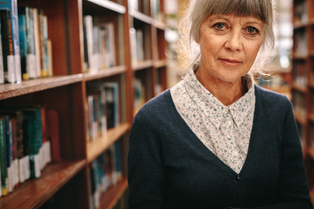 Portrait of a senior woman standing in a library