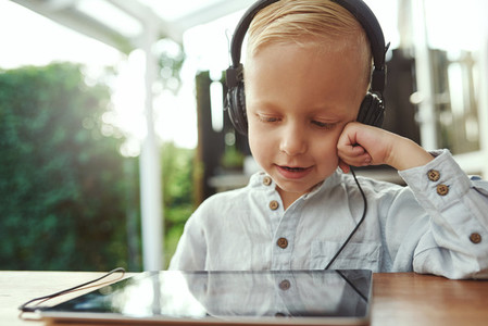 Adorable young boy listening to music