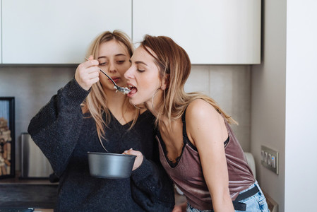 two girls eat porridge at home
