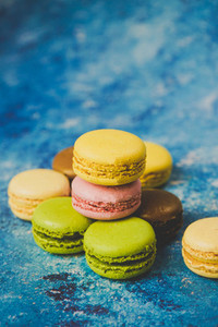 Variety of colorful macarons over a blue background
