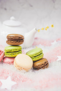 Delicious macarons with a tea in a teapot
