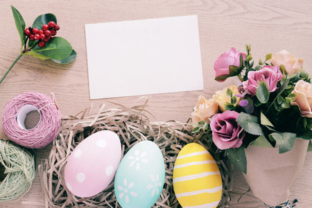 Pastel and colorful easter eggs in nest and bouquet of flower wi