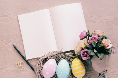 Pastel and colorful easter eggs in nest and bouquet of flower wi