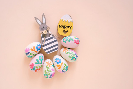 Happy Easter concept with wooden bunny and colorful easter eggs