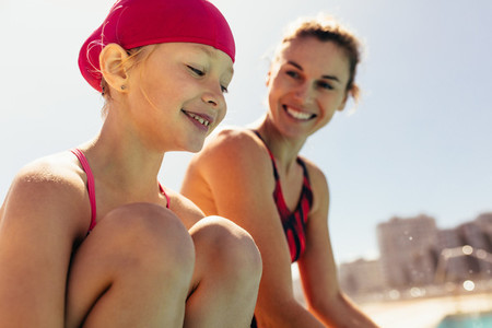 Smiling child with swimming coach