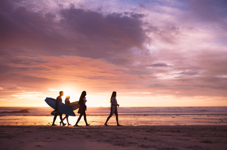 Friends walking on the beach in the evening