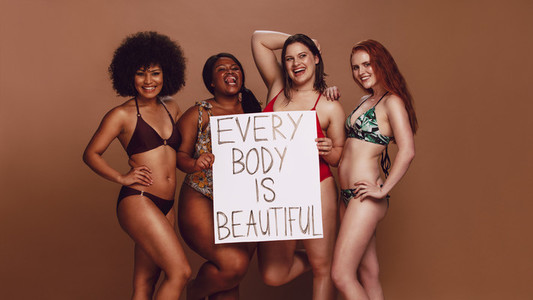 Different size females holding a every body is beautiful placard