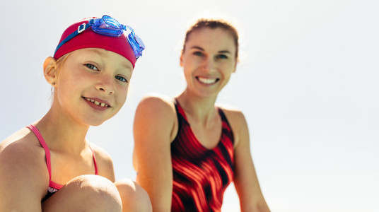 Smiling girl with swimming trainer