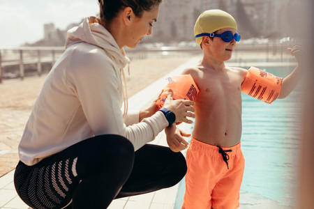 Boy at swimming class with trainer