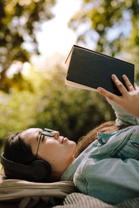 Relaxed woman reading a book outdoors