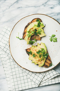 Flat lay of avocado toast on plate over marble background