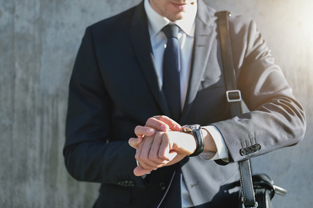 Stylish man wearing suit looks at watch