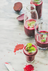 Fresh morning beetroot smoothie or juice in glasses marble background