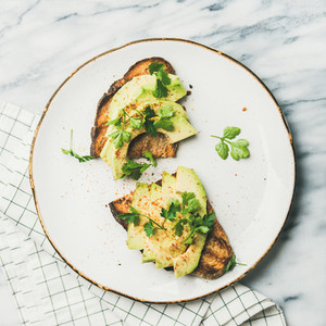 Flat lay of avocado toast over marble background  square crop