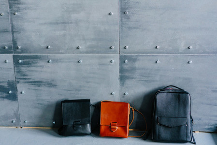 three leather bags on a gray background