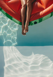 Woman relaxing on a mattress in pool