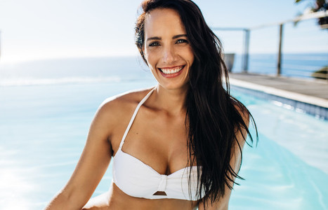 Attractive woman in bikini by the pool