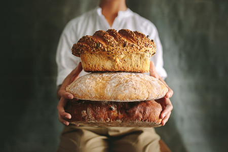 Baker showing various loaf breads