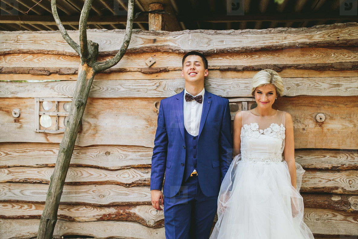 beautiful young wedding couple stands near house