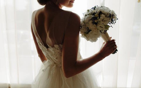 beautiful bride in a wedding dress  by window