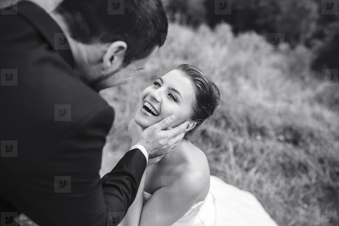 groom gently touches the face of his bride