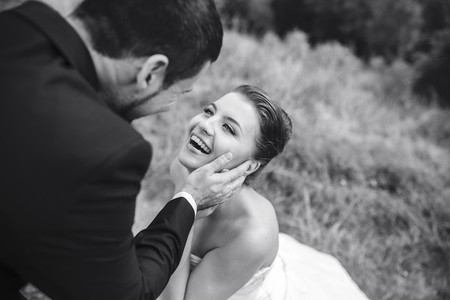 groom gently touches the face of his bride