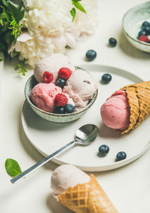 Pink strawberry and coconut ice cream scoops in bowl