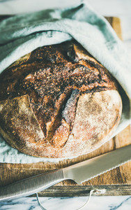 Freshly baked sourdough bread on chopping board  selective focus