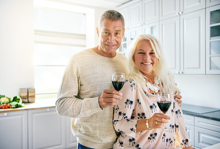 Smiling middle aged couple holding wine glasses