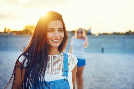 Grinning woman with friend out of focus behind her