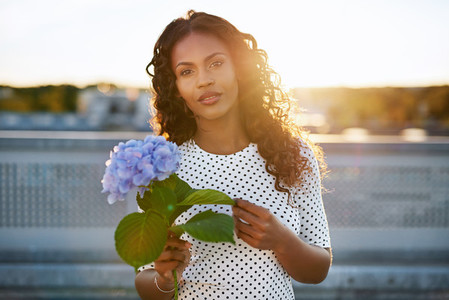 Pretty black woman presenting a flower