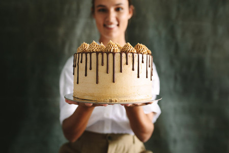 Female baker with a delicious cake