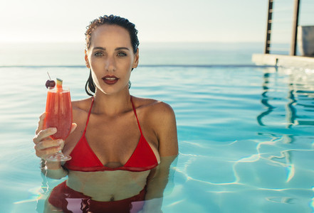 Woman inside a pool with a drink