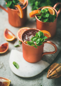 Blood orange Moscow mule alcohol cocktails in mugs on board