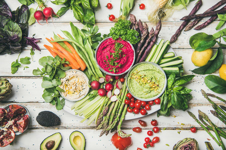 Chickpea  beetroot  spinach hummus dips with colorful vegetables and greens