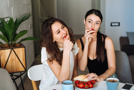 Two woman friends breakfast in the kitchen