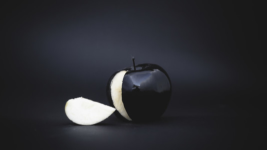 sliced black apple on a background