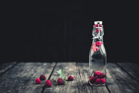 Bottle delicious refreshing drink of raspberry  Wood background