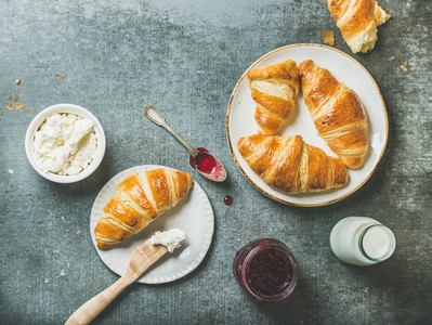 Freshly baked croissants with jam cream cheese and milk in bottle