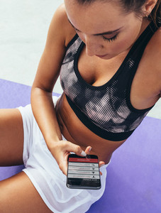 Sportswoman using a gym app for workout