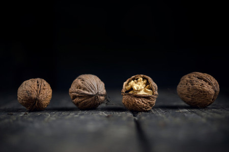 Walnuts on a grey textured wooden table  Assortment of nuts isolated on rustic old wooden background and splintered walnut with heart shaped core  Walnuts close up