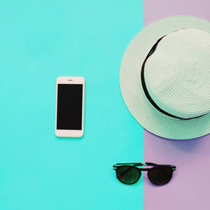 Flat lay fashion of smart phone  panama hat and sunglasses