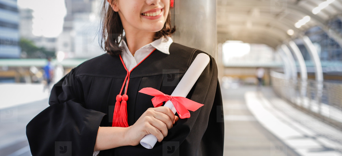 Young student woman smiling and holding diploma certificate
