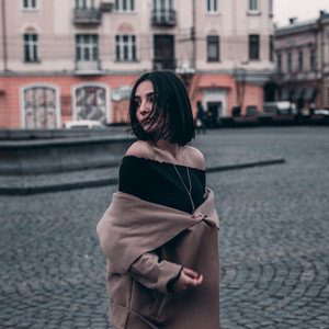 cute brunette in a coat walks around the city