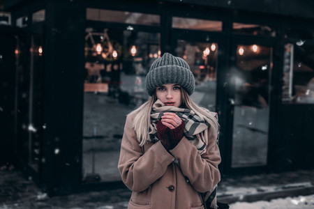 cute girl in a warm hat trying to keep warm