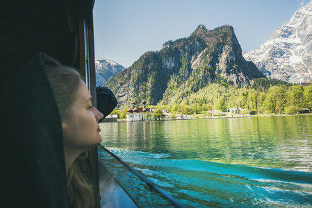 Young woman traveler looking out of window on boat trip at Konigsee Lake in berchtesgaden in Bavaria  Germany